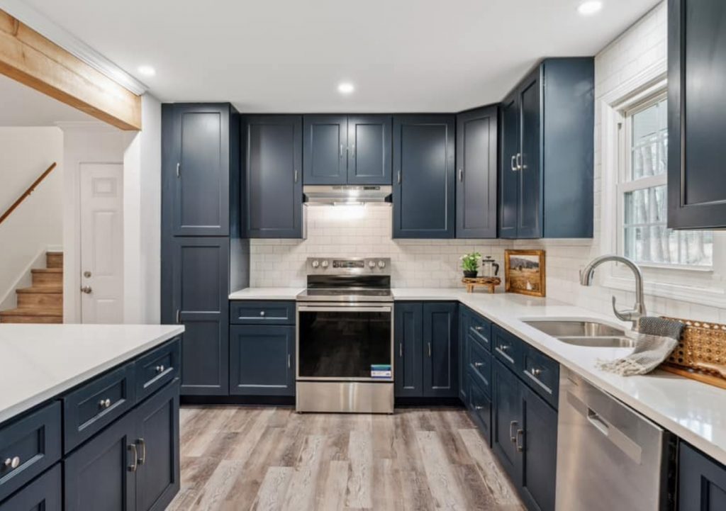 Navy blue kitchen cabinets with white countertops